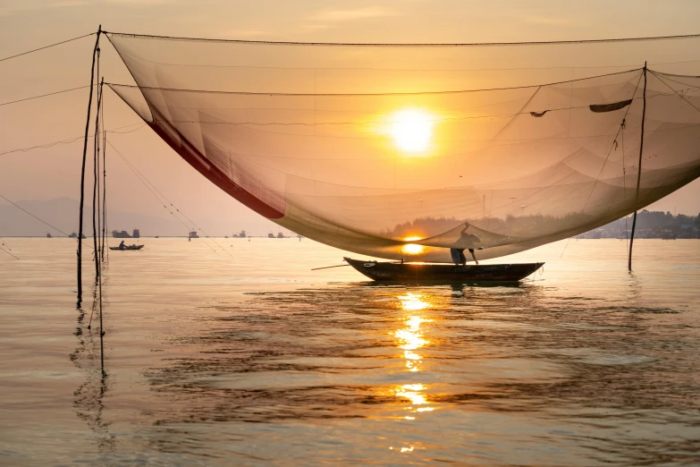 a boat that is sitting in the water, inspired by Steve McCurry, pexels contest winner, asian sun, sail made of human skin, vietnam, warm glow