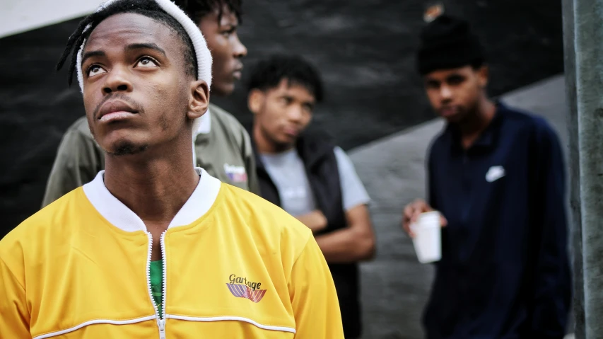 a group of young men standing next to each other, by Lee Gatch, trending on pexels, realism, black and yellow tracksuit, focused on neck, mkbhd, tournament