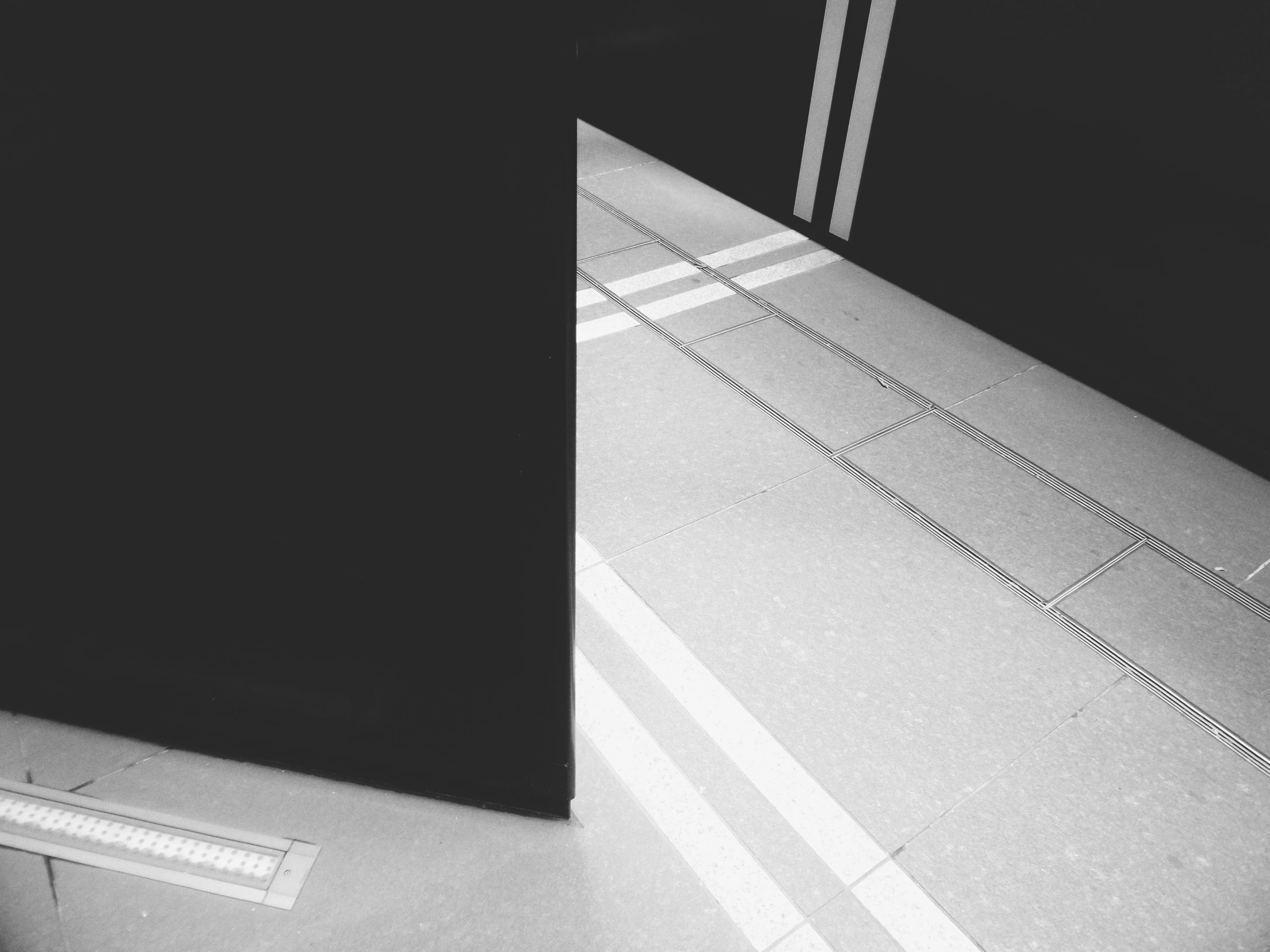 a black and white photo of an open door, a black and white photo, light and space, floor tiles, instagram story, illuminated lines, angular dynamic white rock floor