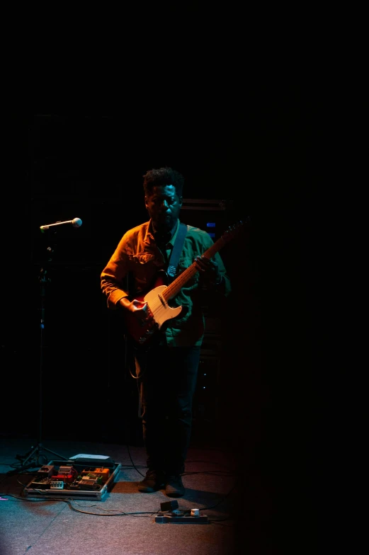 a man playing a guitar in front of a microphone, by Joe Stefanelli, dark-skinned, muted stage effects, slide show, unblur