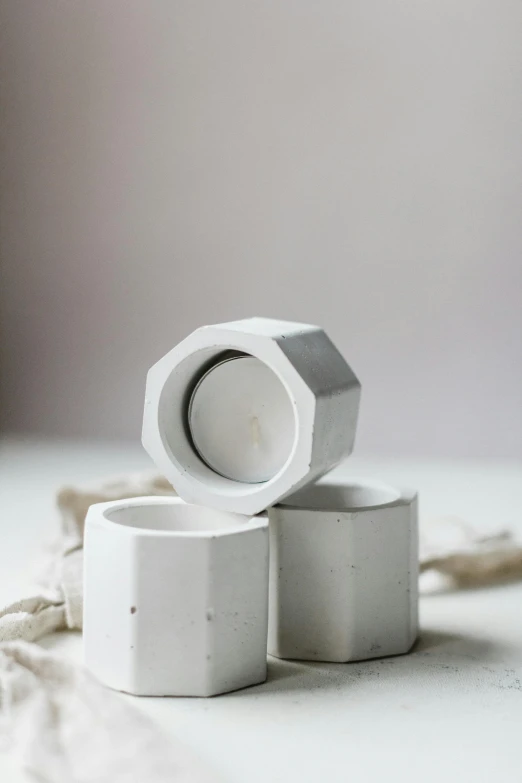 a couple of cups sitting on top of a table, concrete art, hexagonal ring, white: 0.5, little windows, medium sensor