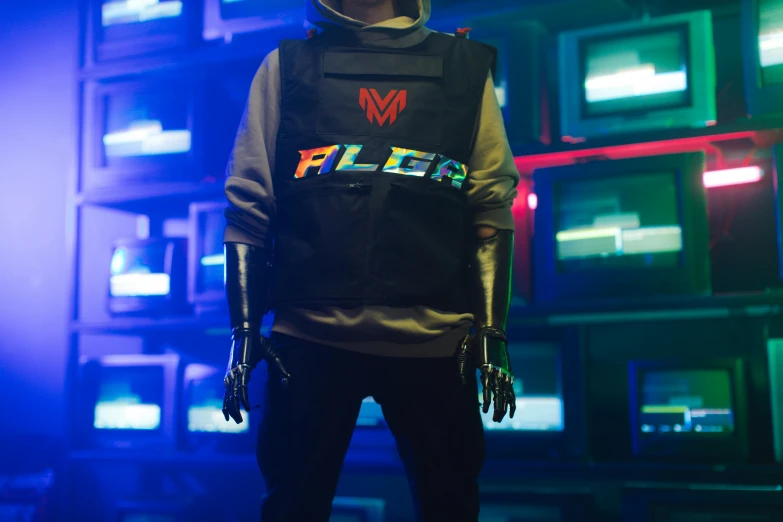 a man standing in front of a wall of televisions, an album cover, inspired by Beeple, altermodern, black swat vest, moira from overwatch, official store photo, photograph of three ravers