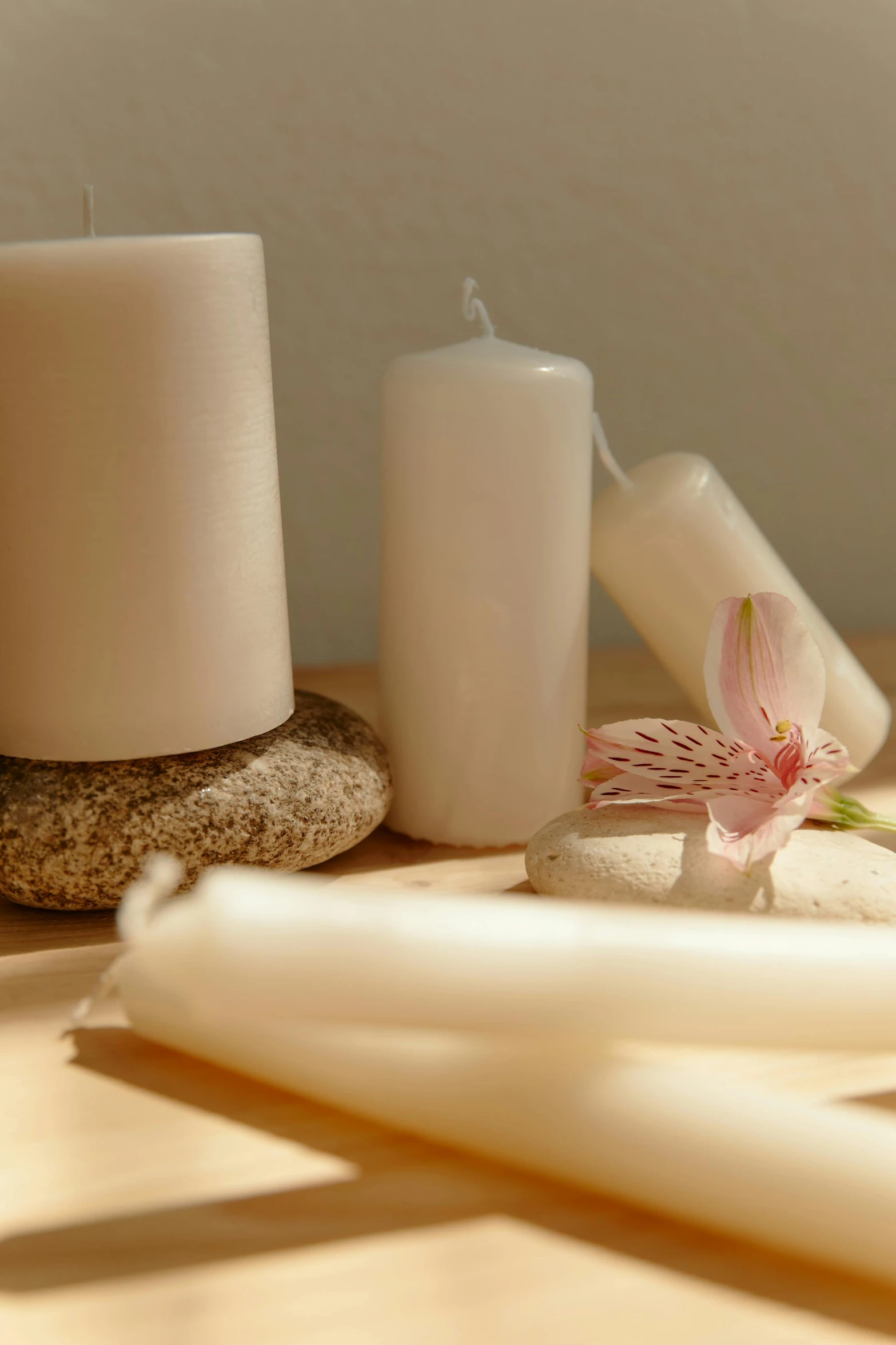 a group of candles sitting on top of a wooden table, orchid stems, healing tubes, white ceramic shapes, soft lighting |