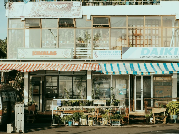 a building with a car parked in front of it, a photo, unsplash, food stall, kahikatea, awnings, coastal