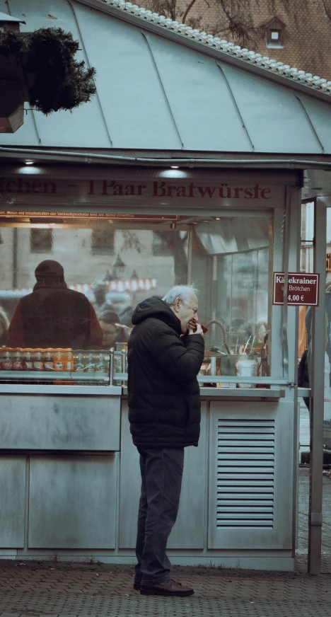 a man standing in front of a food stand, by Adam Marczyński, pexels contest winner, realism, white-haired, shopwindows, berlin, low quality footage