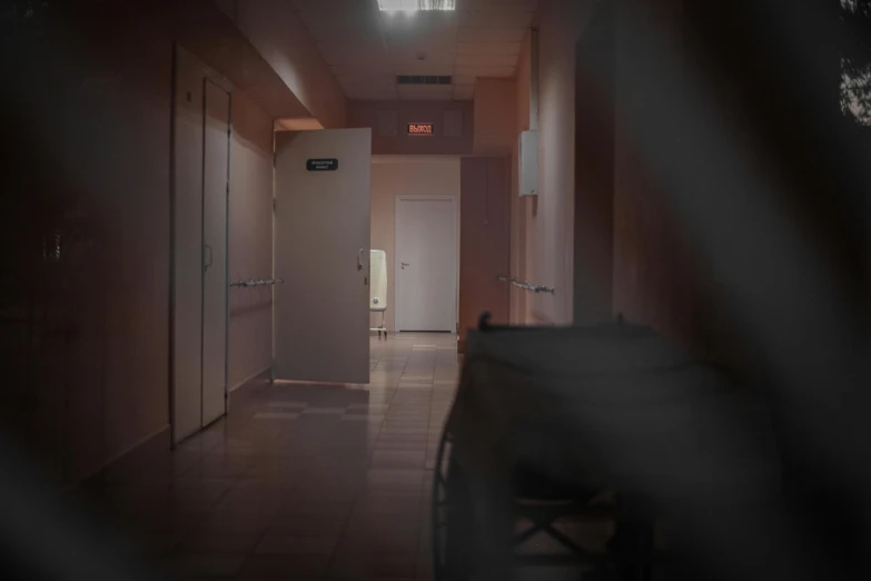 a hallway with a chair in the middle of it, by Elsa Bleda, pexels, happening, medical lighting, background image, movie still of a tired, spooky found footage