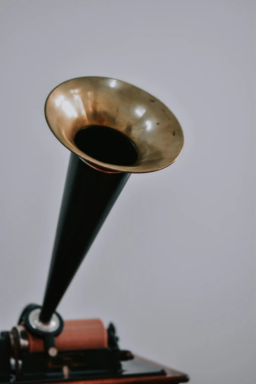 an old gramphone sitting on top of a table, an album cover, unsplash, modernism, trumpet, gold and black metal, larynx, large tall