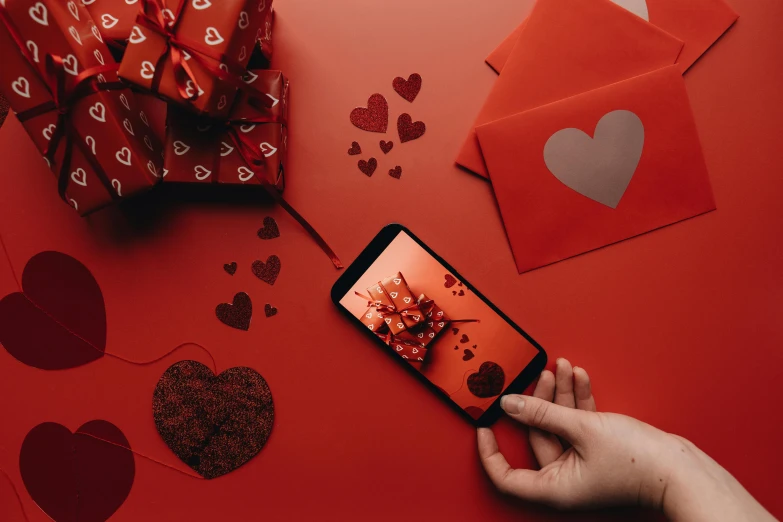 a person taking a picture of valentine's day, trending on pexels, hurufiyya, entwined hearts and spades, maroon, presents, diecut