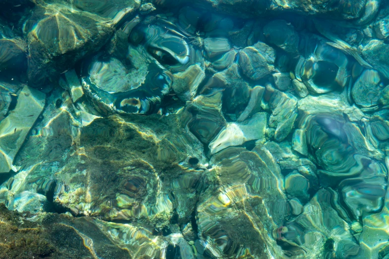 a number of rocks in a body of water, an album cover, inspired by Nassos Daphnis, unsplash, dappled light, refractions, seafloor, iphone wallpaper