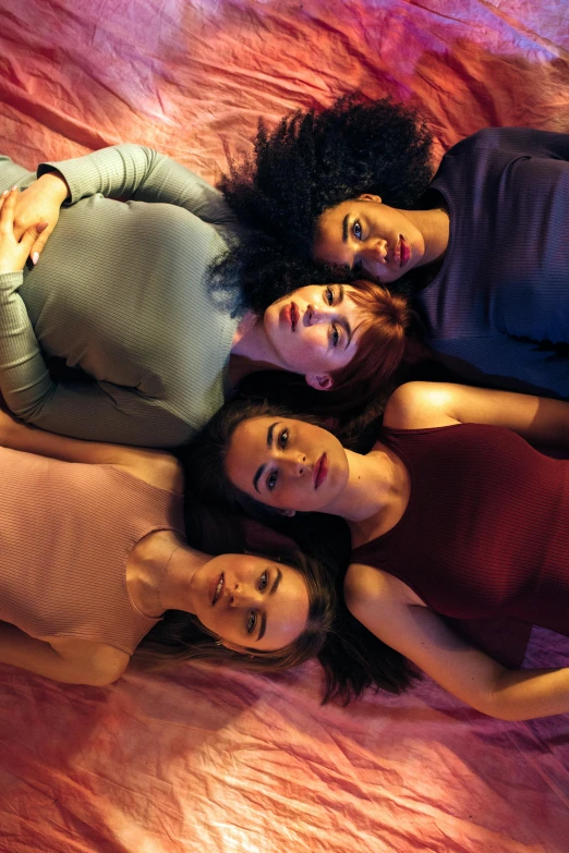 a group of women laying on top of a bed, inspired by Nan Goldin, trending on pexels, renaissance, mauve and cinnabar and cyan, portrait 8 k, multicoloured, prana