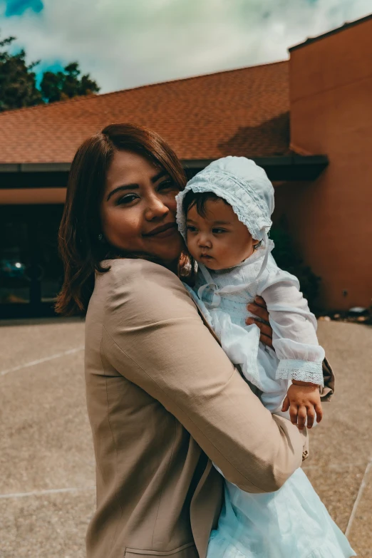 a woman holding a baby in her arms, pexels contest winner, isabela moner, lightly dressed, malaysian, square