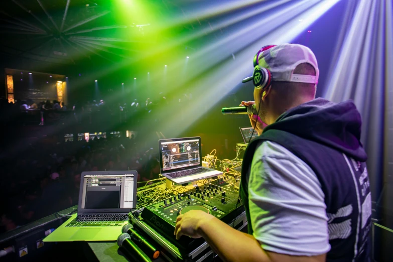 a man that is sitting in front of a laptop, by Robbie Trevino, stage at a club, avatar image, stage lighting, sports photo