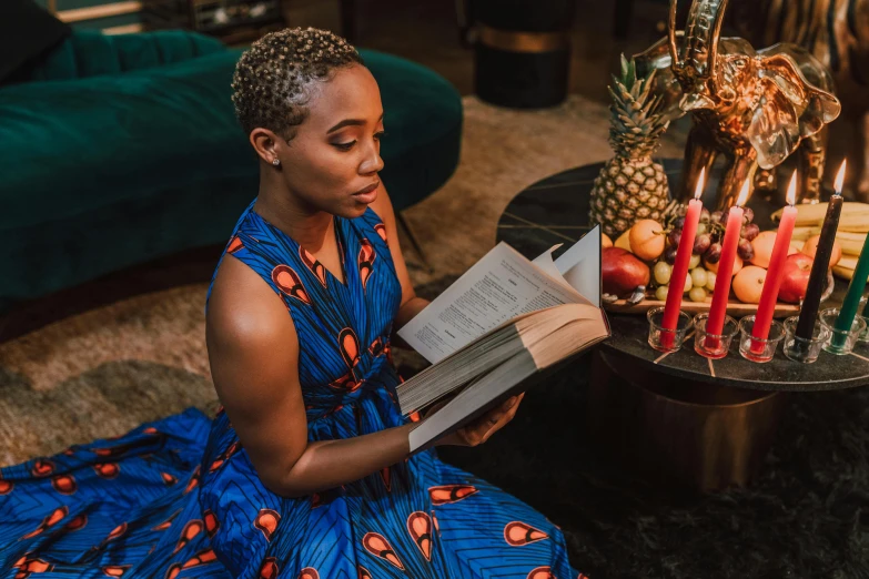 a woman sitting on the floor reading a book, a portrait, by Julia Pishtar, pexels contest winner, afrofuturism, wearing an african dress, reading for a party, elegantly dressed, youtube thumbnail