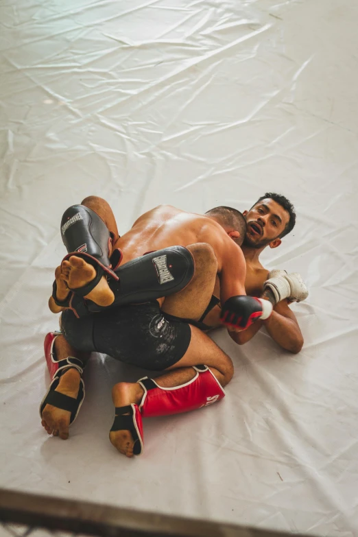 a man laying on top of a wrestling mat, pexels contest winner, renaissance, muscular men entwined together, kickboxing, india, square