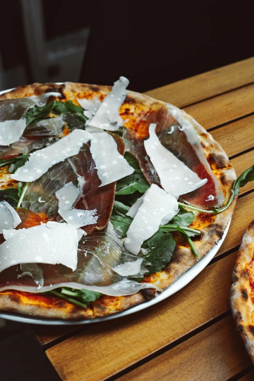 two pizzas sitting on top of a wooden table, by Carlo Martini, fig leaves, thumbnail, manhattan, overview