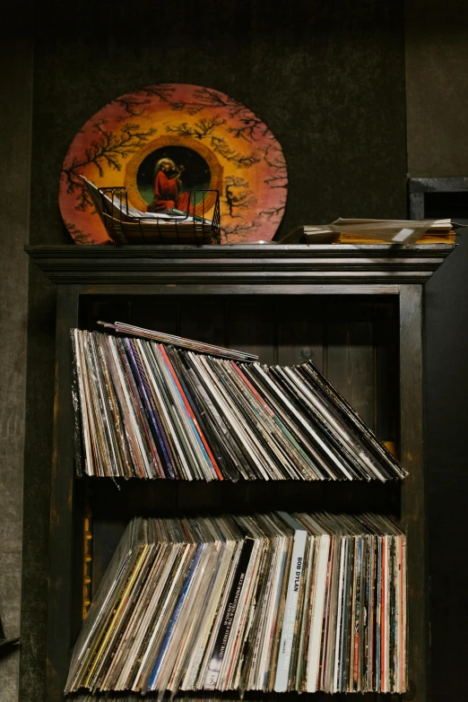 a bookshelf with a bunch of records on top of it, an album cover, back room, rich detail, on display, contain