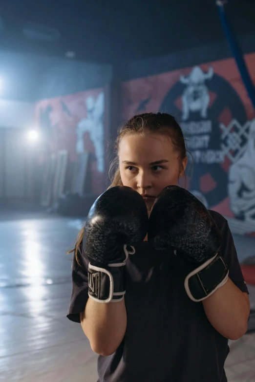 a close up of a person wearing boxing gloves, inspired by Louisa Matthíasdóttir, happening, teenager girl, in a dojo, powerful stance, joey king