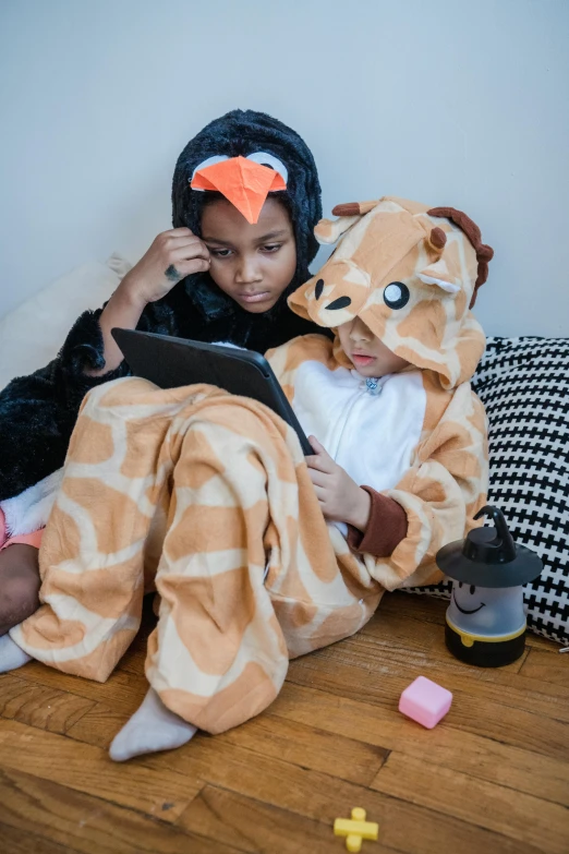 a woman in a giraffe costume using a tablet, by Nina Hamnett, pexels, girls resting, close together, boys, slide show