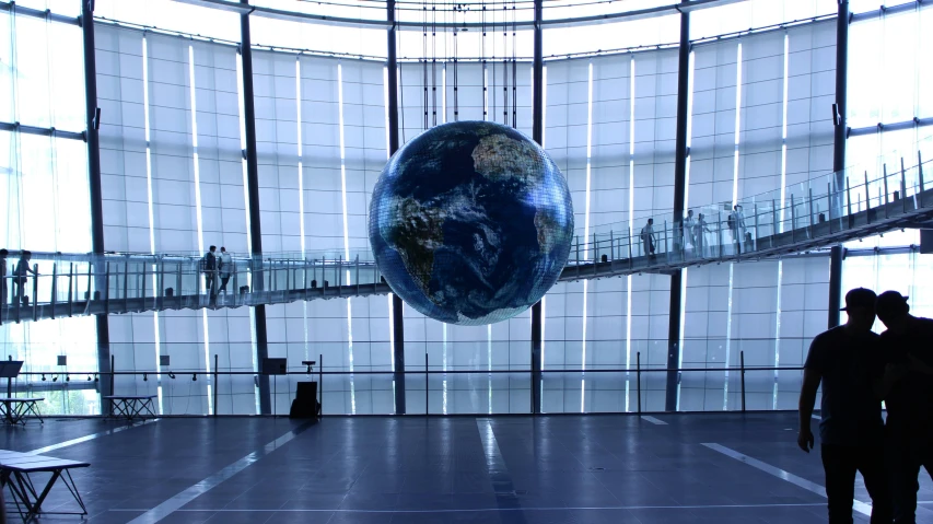 a couple of people that are standing in a building, inspired by Thomas Struth, unsplash, hyperrealism, earth globe on top, orrery, museum quality photo, thumbnail