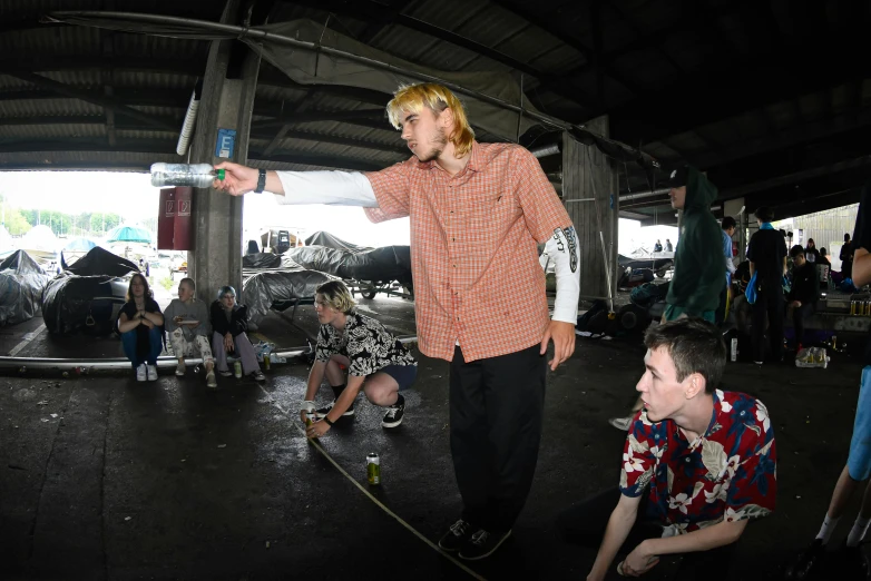 a man riding a skateboard up the side of a ramp, a portrait, reddit, rapping on stage at festival, maintenance photo, te pae, person in foreground