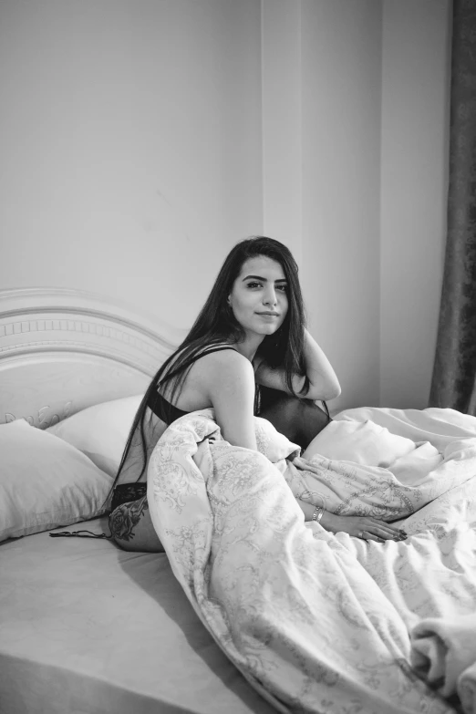 a black and white photo of a woman laying in bed, a black and white photo, inspired by Elsa Bleda, reddit, middle eastern, young woman with long dark hair, aida muluneh, various posed