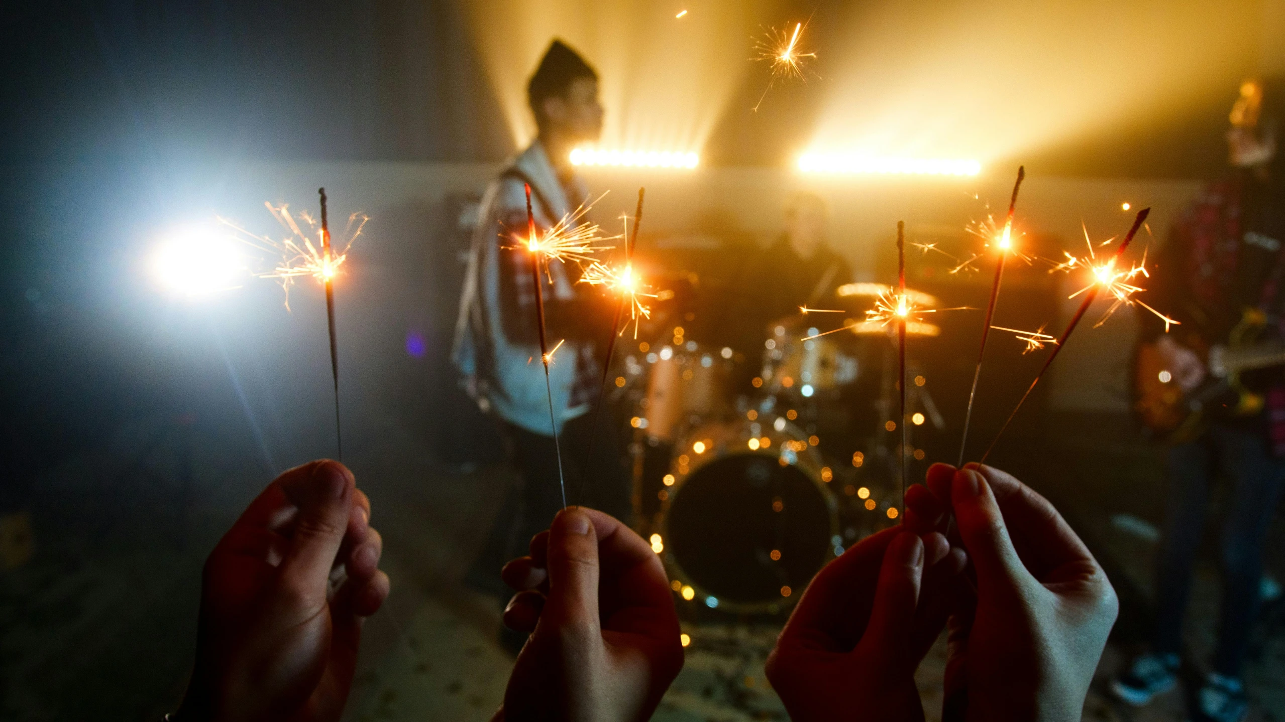 a group of people holding sparklers in their hands, an album cover, pexels contest winner, band playing instruments, brandon woelfel, medium detail, shot on sony a 7