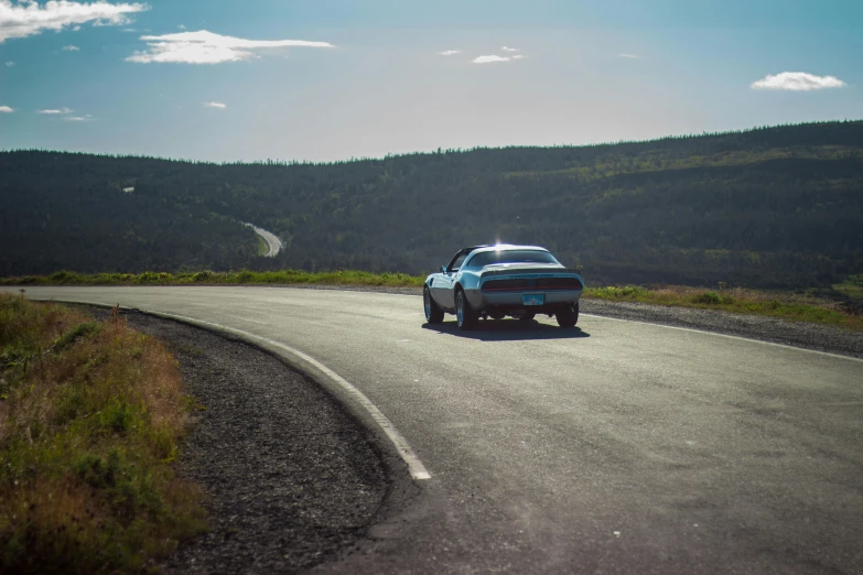 a car that is sitting on the side of a road, by Haukur Halldórsson, pexels contest winner, hurufiyya, 80s outrun, panoramic shot, some of the blacktop is showing, nordic summer