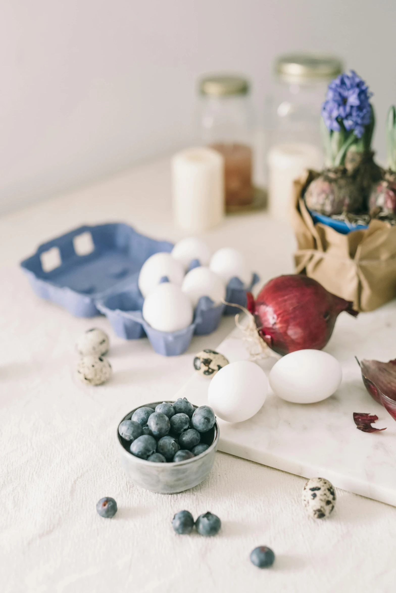 a white table topped with eggs and blueberries, a still life, unsplash, decorations, multiple stories, mid shot photo