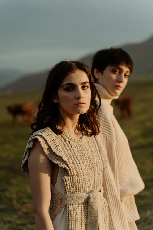 two people standing next to each other in a field, an album cover, by irakli nadar, renaissance, looking serious, hila klein, loosely cropped, cliffs