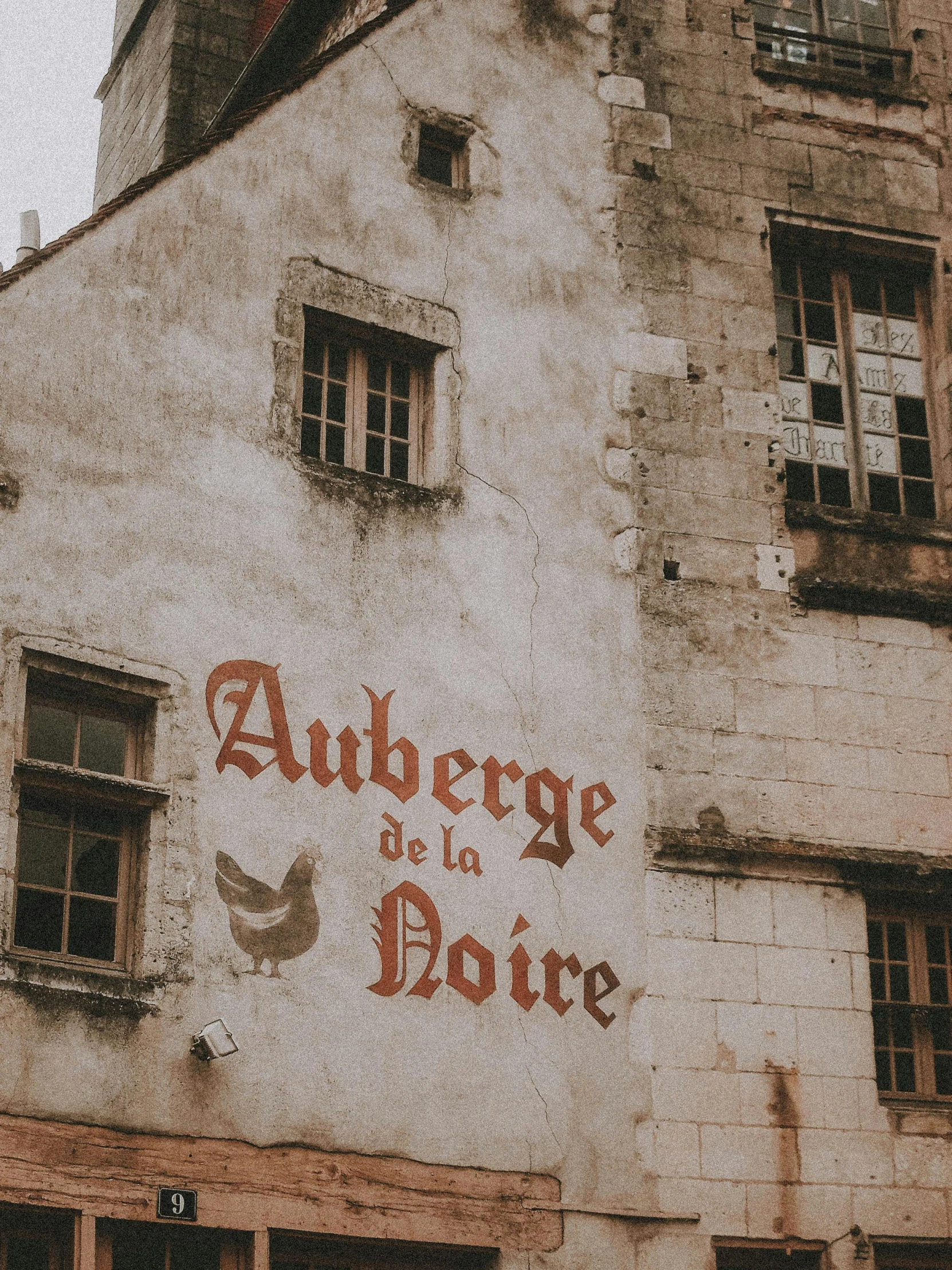 a building with a sign on the side of it, inspired by Étienne Aubry, pexels contest winner, arabesque, french village interior, grunge wall, beige, ad image