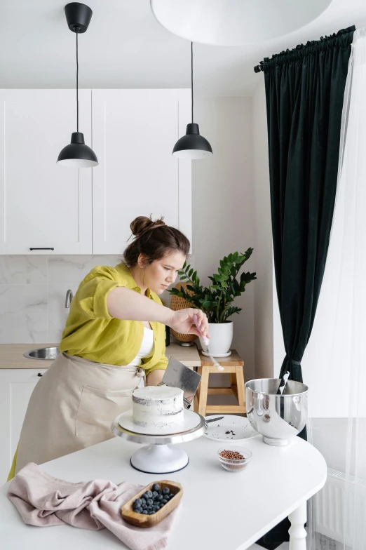 a woman standing in a kitchen preparing food, inspired by Yukimasa Ida, pexels contest winner, cake sculpture, white table, gif, glaze