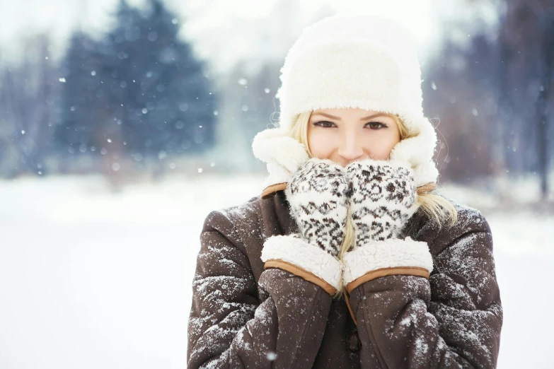 a woman covering her face in the snow, a portrait, shutterstock, square, gloves, white, a blond