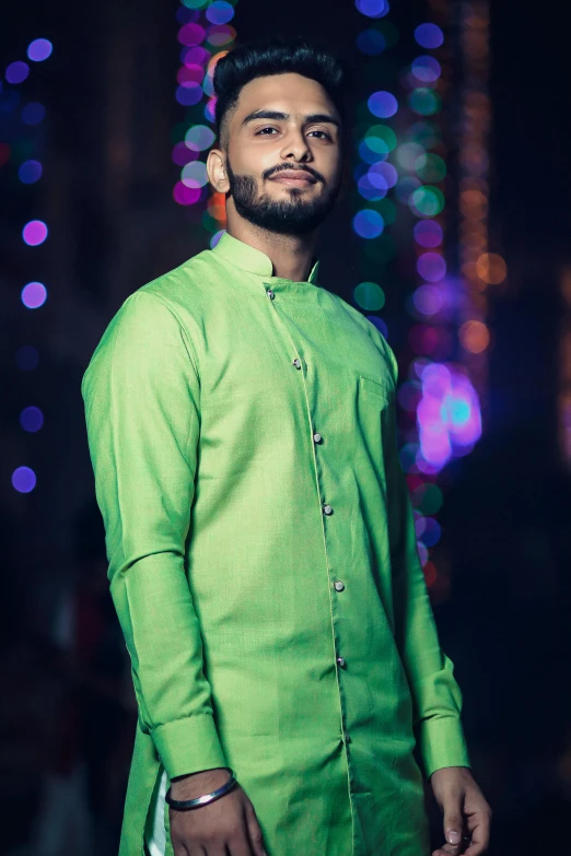 a man in a green shirt and white pants, inspired by Saurabh Jethani, pexels, hurufiyya, wearing bihu dress mekhela sador, with neon lights, ((portrait)), muslim