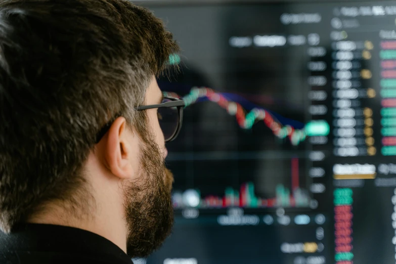 a man looking at graphs on a computer screen, trending on unsplash, realistic », crypto valut, looking from side, schools