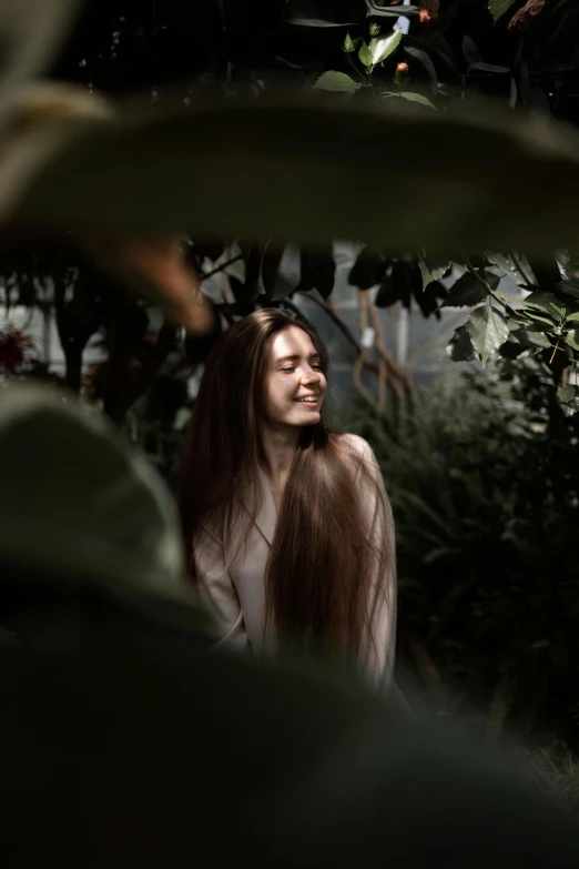 a woman with long hair standing in a greenhouse, pexels contest winner, turning her head and smiling, asian girl, softly lit, with a long