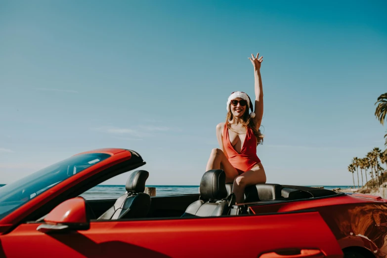 a woman sitting on top of a red convertible car, pexels contest winner, is wearing a swimsuit, victory lap, avatar image, lachlan bailey