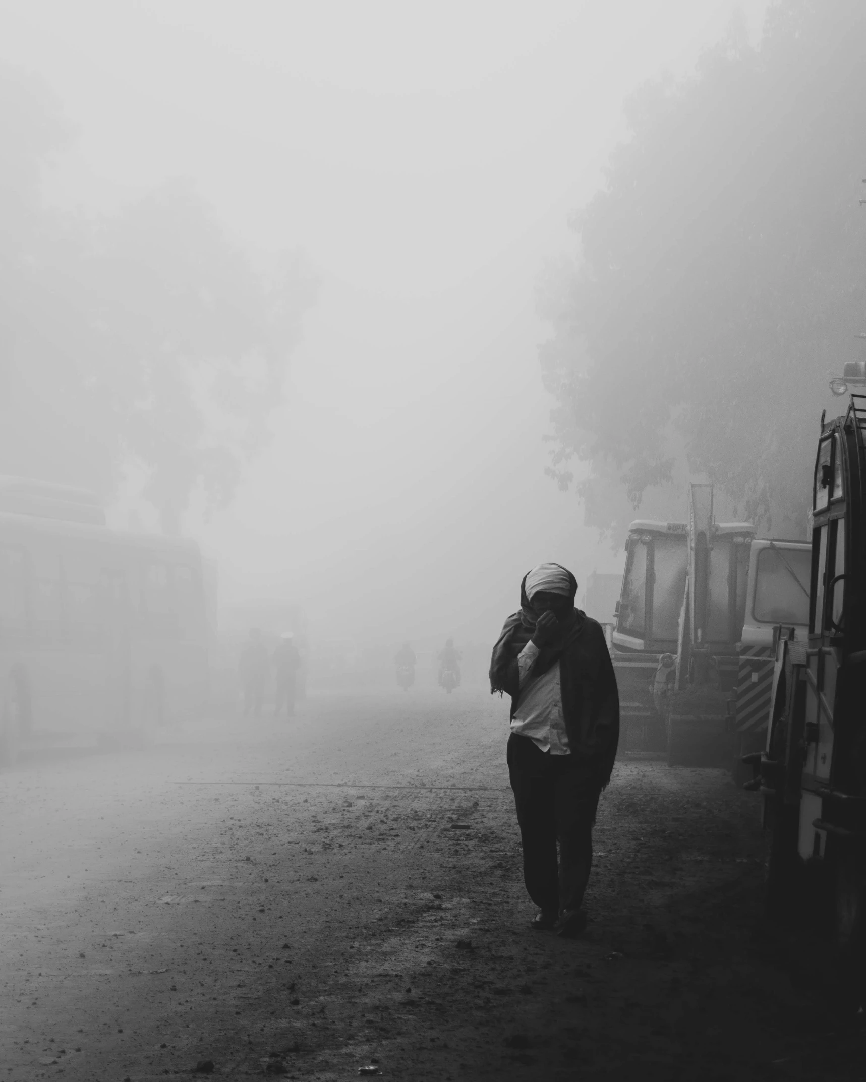 a black and white photo of a man walking down a foggy street, by Lucia Peka, pexels contest winner, nepal, hugging, polluted, ilustration