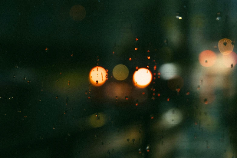 a view of a city at night through a rainy window, pexels contest winner, tonalism, bright headlights, close - up bokeh, orange light, instagram post