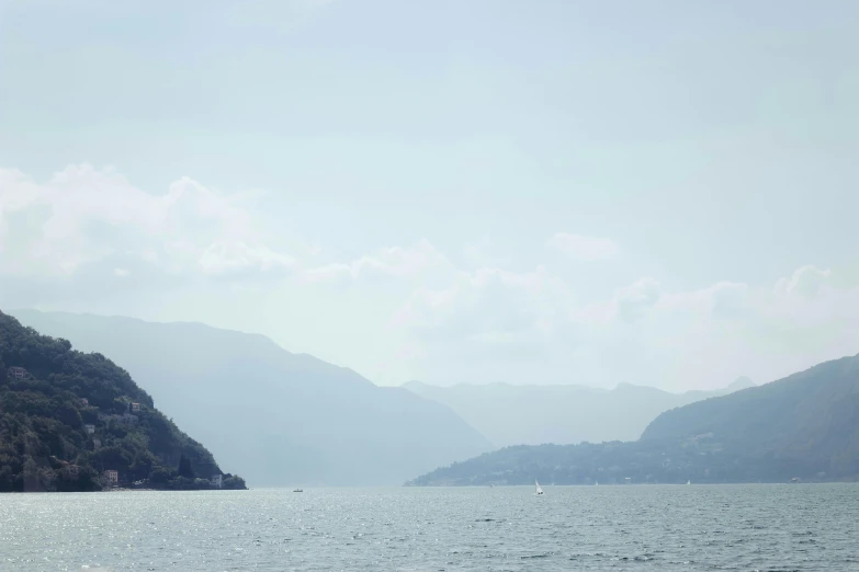 a large body of water with mountains in the background, by Julia Pishtar, pexels contest winner, romanticism, vouge italy, slight haze, thumbnail, fjords