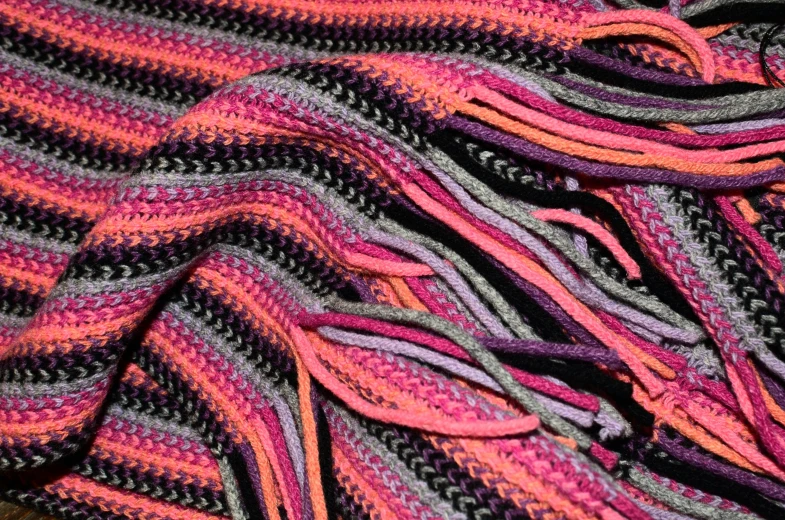 a multicolored scarf sitting on top of a table, a stipple, flickr, hot pink and black, fringe, full of colour 8-w 1024, hdr detail