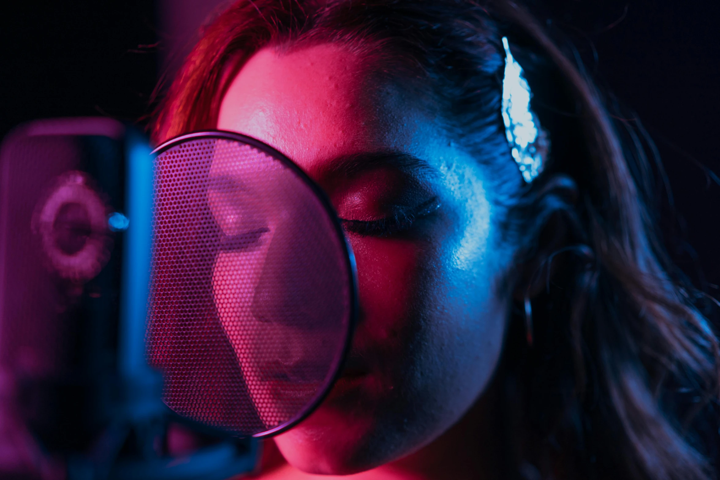 a woman looking through a magnifying glass, an album cover, inspired by Elsa Bleda, trending on pexels, holography, red mesh in the facede, shot at night with studio lights, pink and blue lighting, vocal