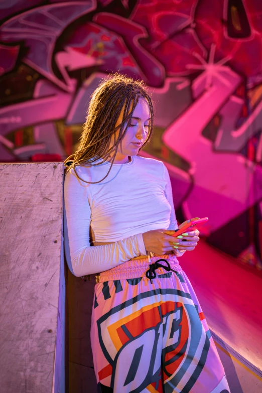 a woman leaning against a wall using a cell phone, an album cover, trending on pexels, happening, colourful lighting, at a rave, chloe bennet, cinematic outfit photo