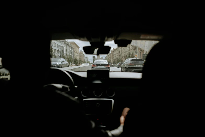 a person driving a car on a city street, pexels contest winner, view from inside, square, black car, panoramic anamorphic