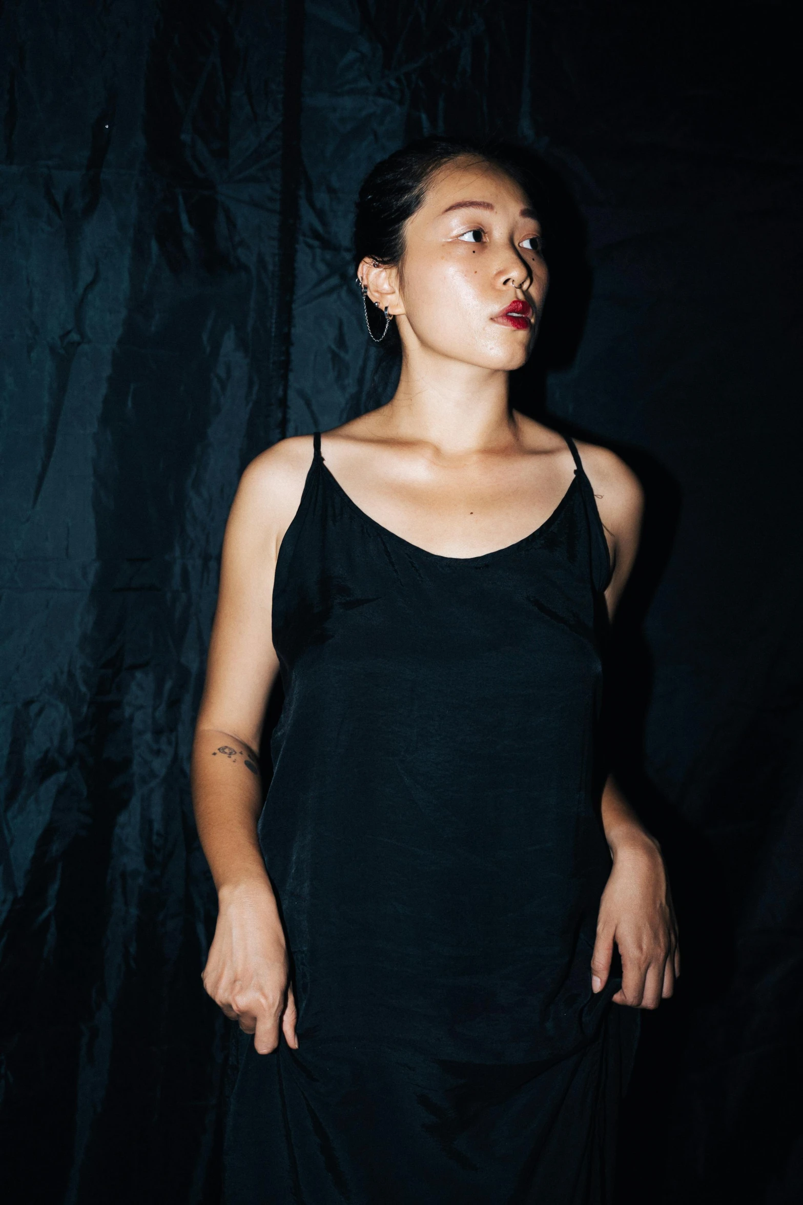 a woman in a black dress posing for a picture, an album cover, inspired by Taro Yamamoto, unsplash, wearing : tanktop, studio portrait, asian descent, nighttime