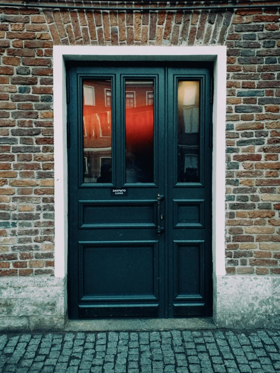 a red fire hydrant sitting in front of a green door, by Jan Tengnagel, pexels contest winner, renaissance, black windows, exiting store, seen from outside, brick building