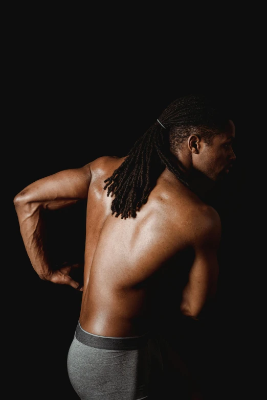 a man with dreadlocks standing in front of a black background, inspired by Terrell James, lower back, showing strong muscles, profile image, instagram photo