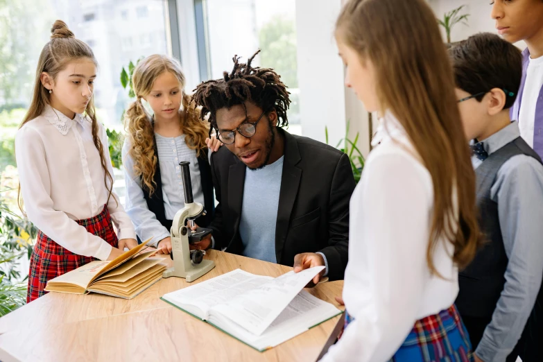 a group of young people standing around a table, pexels contest winner, academic art, nerdy music teacher with phd, little kid, inspect in inventory image, varying ethnicities