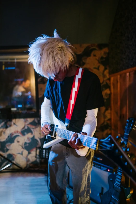 a man that is playing a guitar in a room, an album cover, inspired by Tadanori Yokoo, unsplash, private press, crazy white hair, playing guitar onstage, loosely cropped, gorillaz phase 1