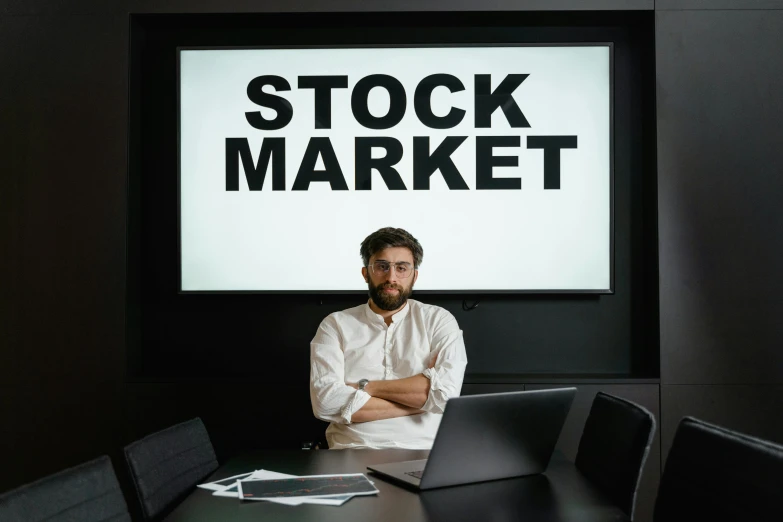 a man sitting at a table with a laptop in front of him, a photo, pexels, renaissance, trading stocks, avatar image, a person standing in front of a, structure : kyle lambert