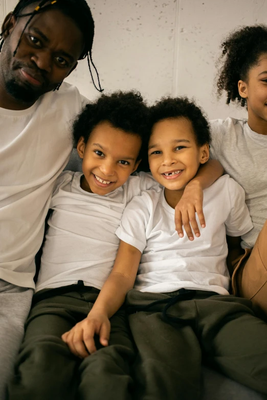 a group of people sitting on top of a bed, by Washington Allston, pexels contest winner, incoherents, caring fatherly wide forehead, black main color, cute boys, slide show